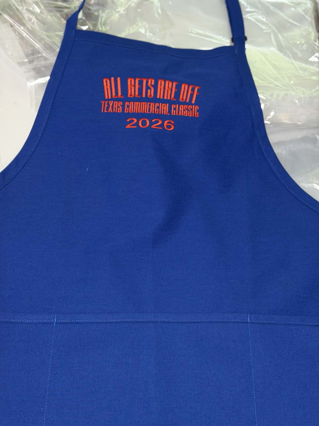 Royal blue apron with All Bets Are Off Texas Commercial Classic 2026